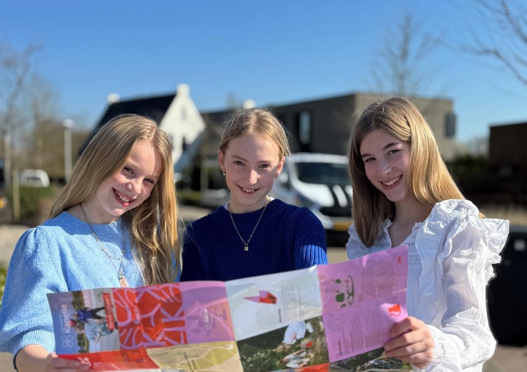 3 meisjes staan buiten met de beweegkaart in hun handen
