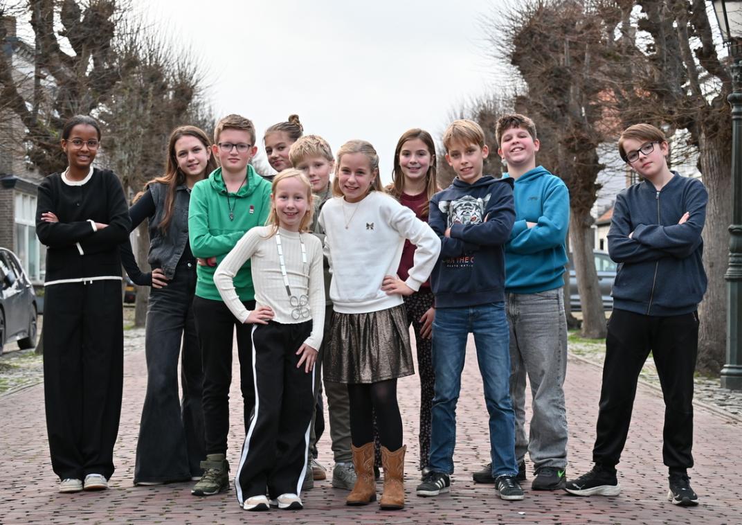Leden van de kinderraad en de kinderburgemeester staan buiten bij elkaar