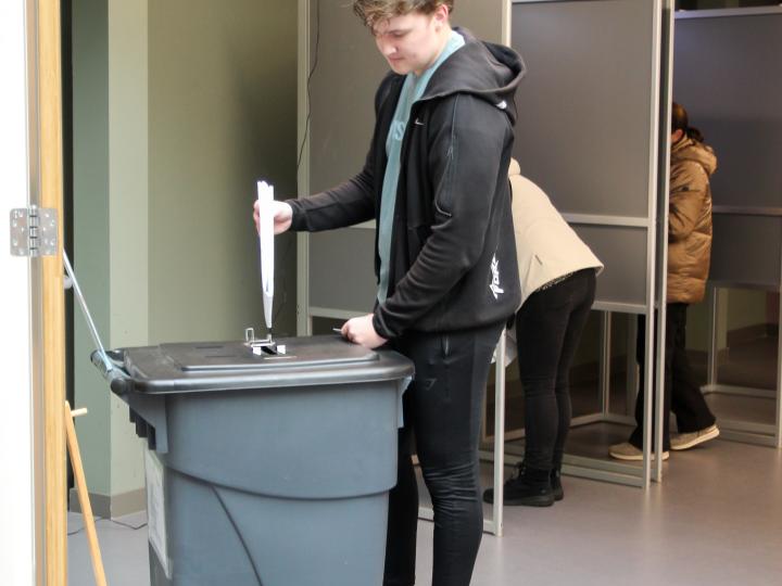 Jongen gooit stembiljet in stembus