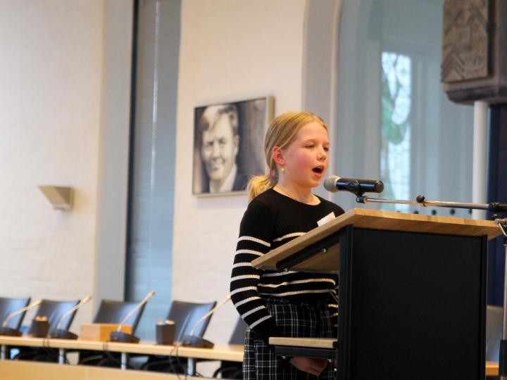 Meisje geeft toespraak in gemeentehuis