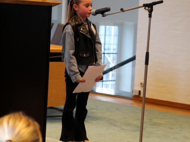 Meisje geeft toespraak in gemeentehuis