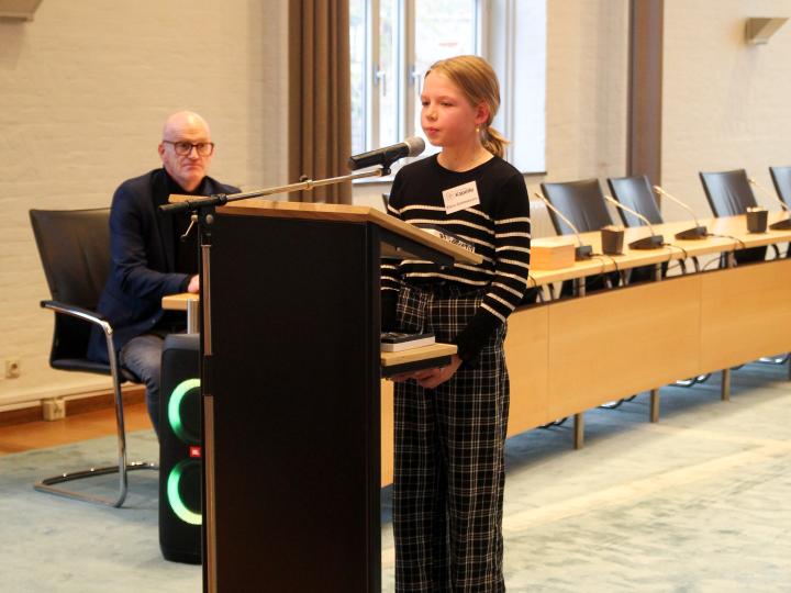 Meisje geeft toespraak in gemeentehuis voor kinderburgemeester verkiezing