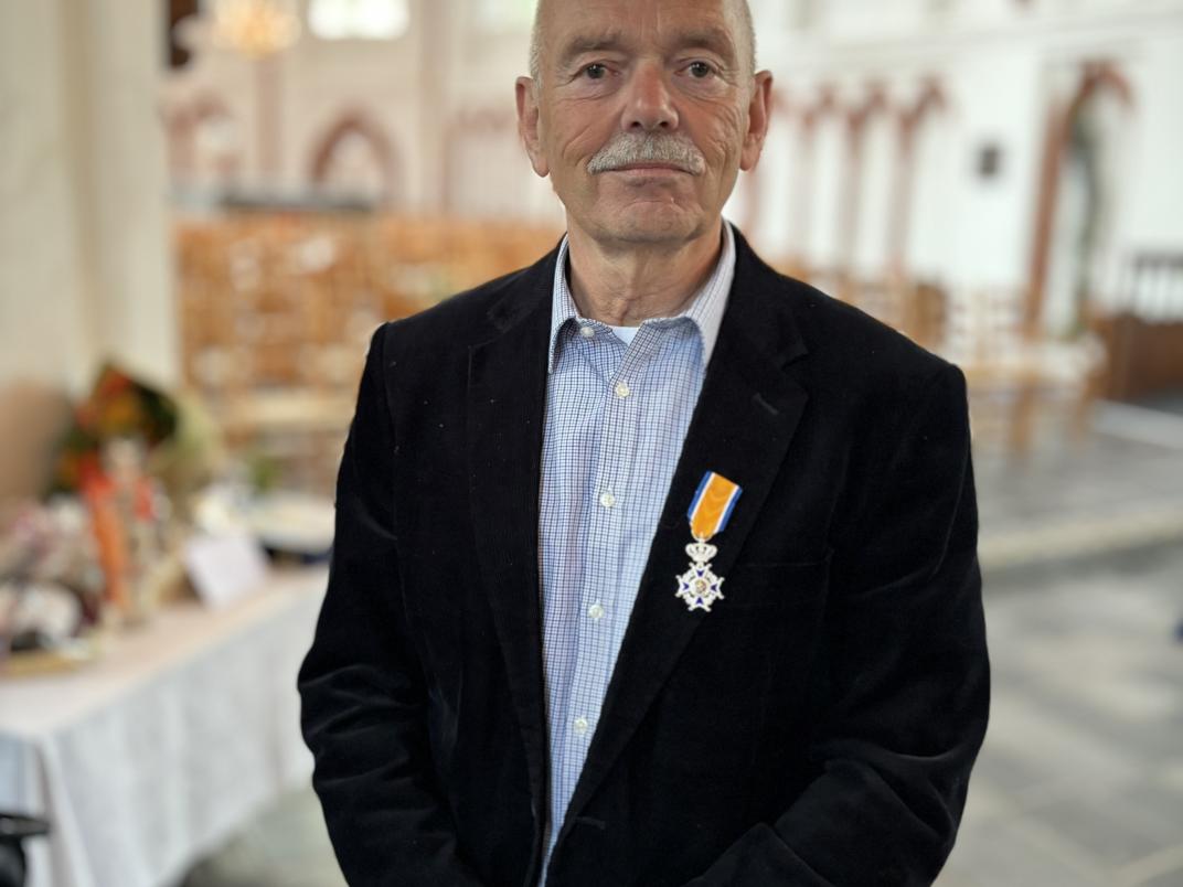 Meneer in kerk met lintje