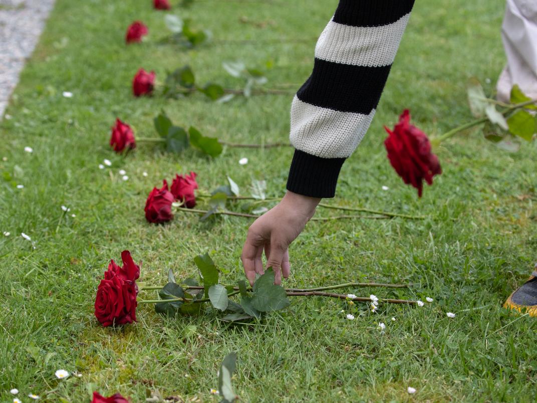 Basisschoolkinderen leggen rozen op de graven