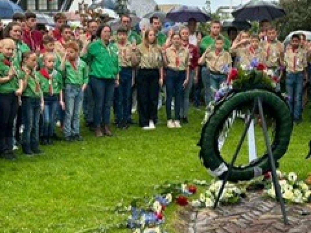 Groep van scouting staat rondom monument