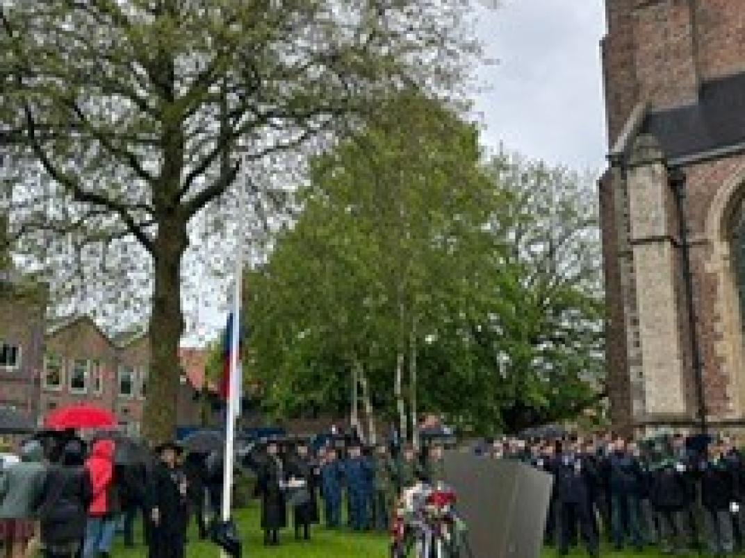 Overzichtsfoto nationele herdenking. Mensen, kerk, monument en krans