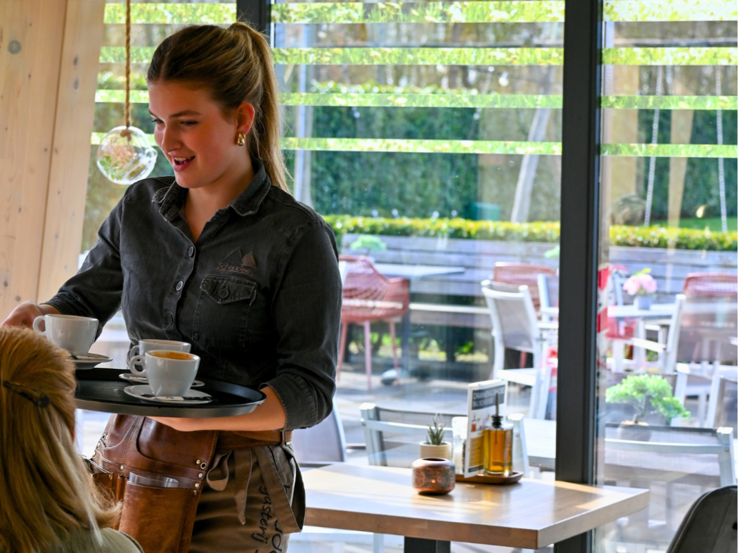 Bediening dat koffie uitserveert in Gasterij Schoudee