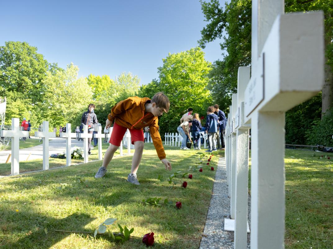 Kinderen leggen rozen bij de graven