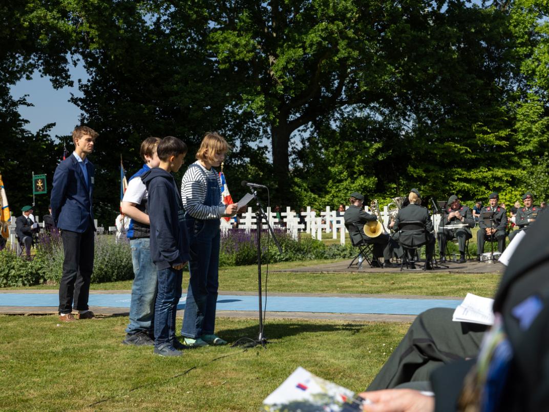 Kinderen lezen een gedicht voor tijdens de Franse Herdenking
