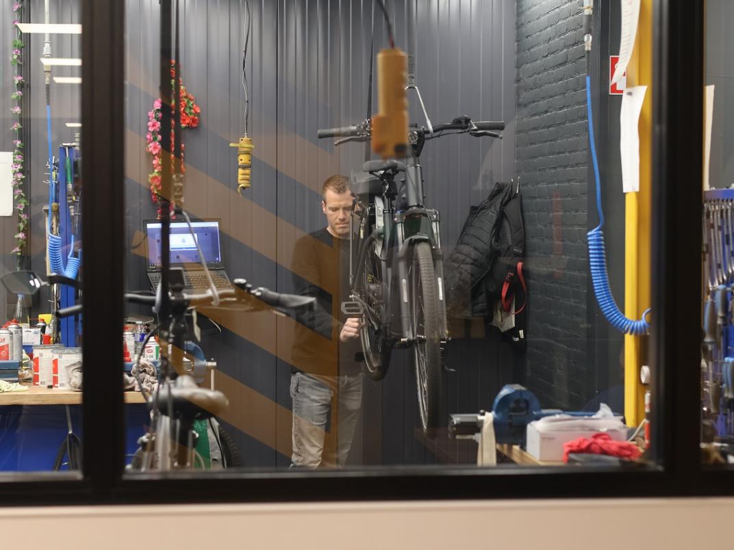 Medewerker fietsenwinkel aan het werk aan een fiets