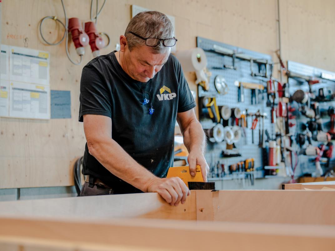 Medewerker VKP in magazijn bezig met hout