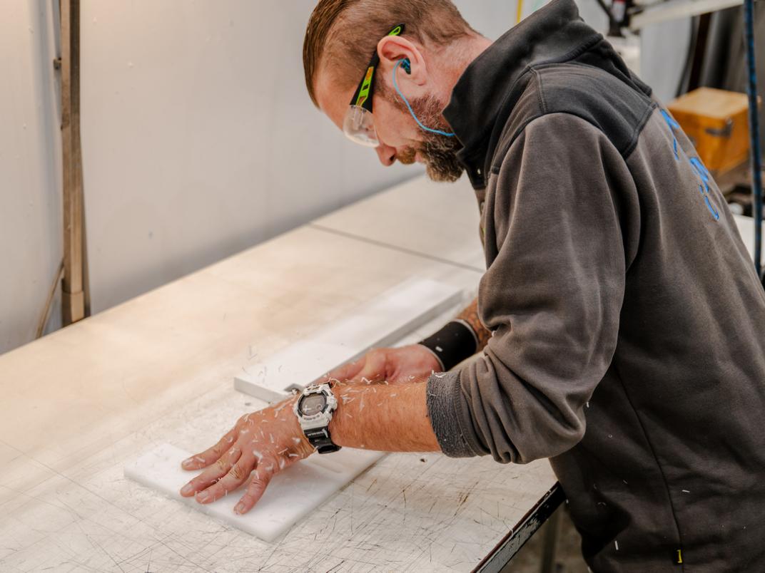 Medewerker met veiligheidsbril op aan het werk