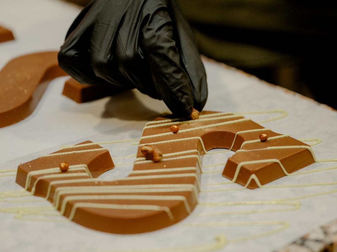 Een chocoladeletter wordt gedecoreerd
